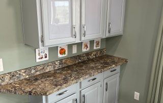 White cabinets in a kitchen with marble table-top