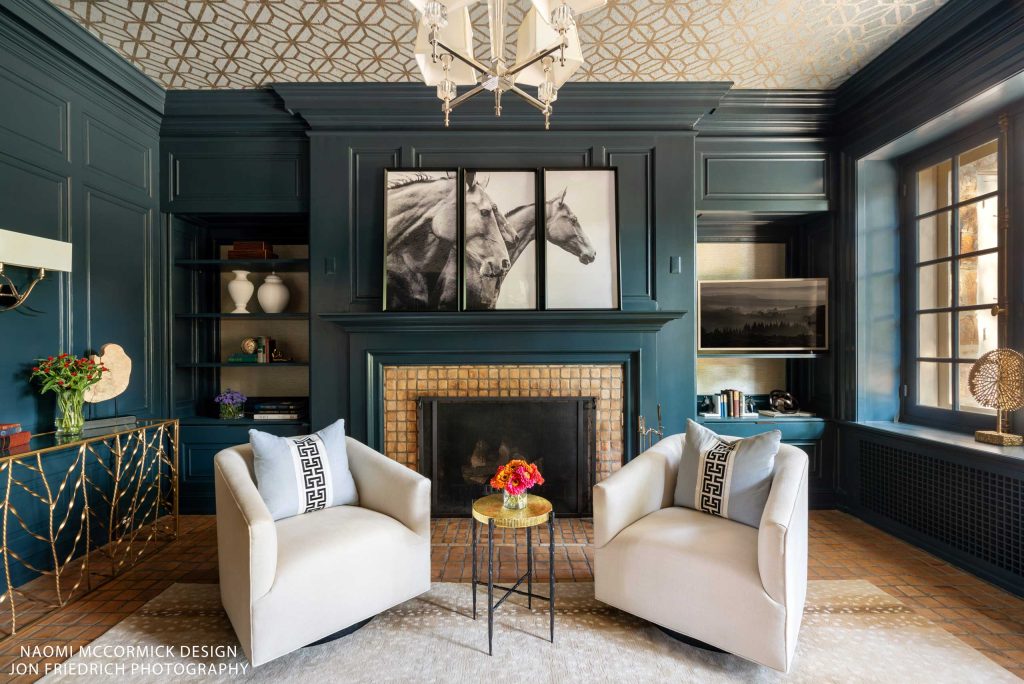 Room with wood walls painted blue and gold pattern on ceiling